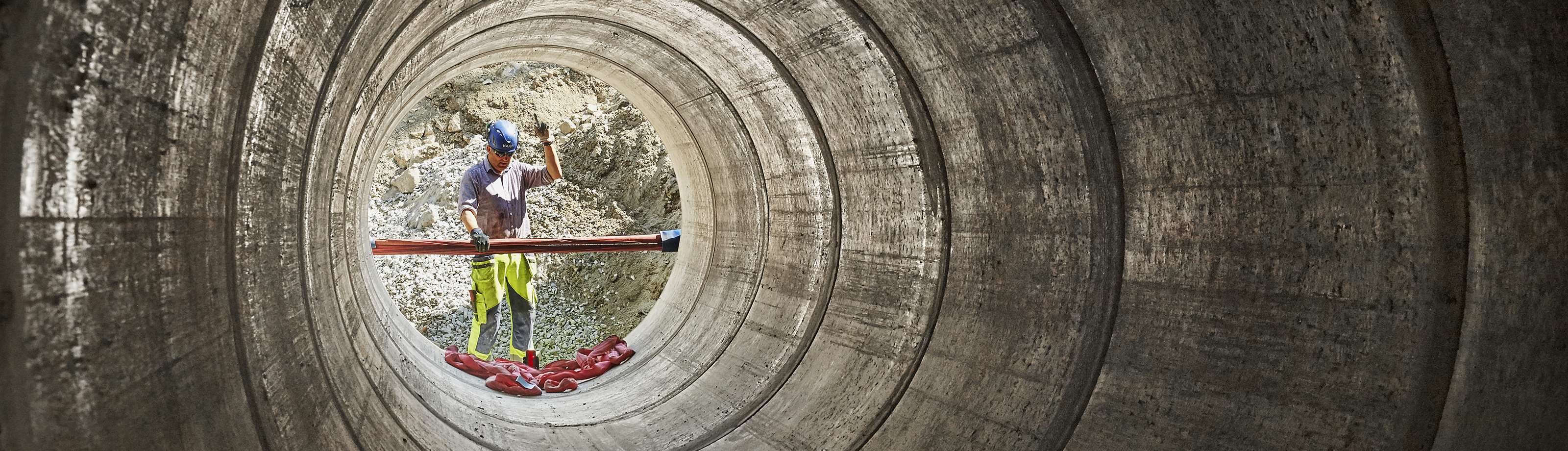 En man jobbar med montering av ett stort rör. 