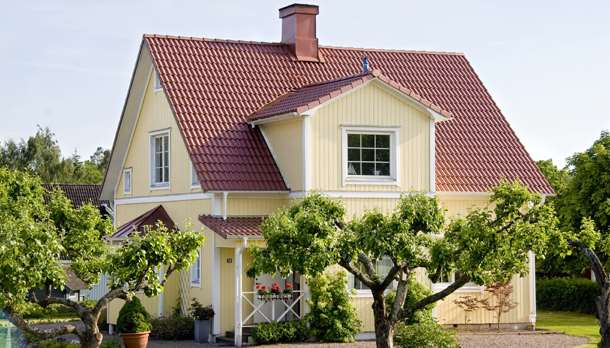 Mysig ljusgul villa men nytt kopparfärgat tak på. Gammal trädgård med äppleträd.