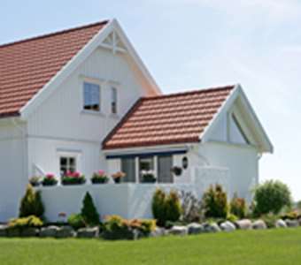 Ett vitt hus med Benders takpannor på.