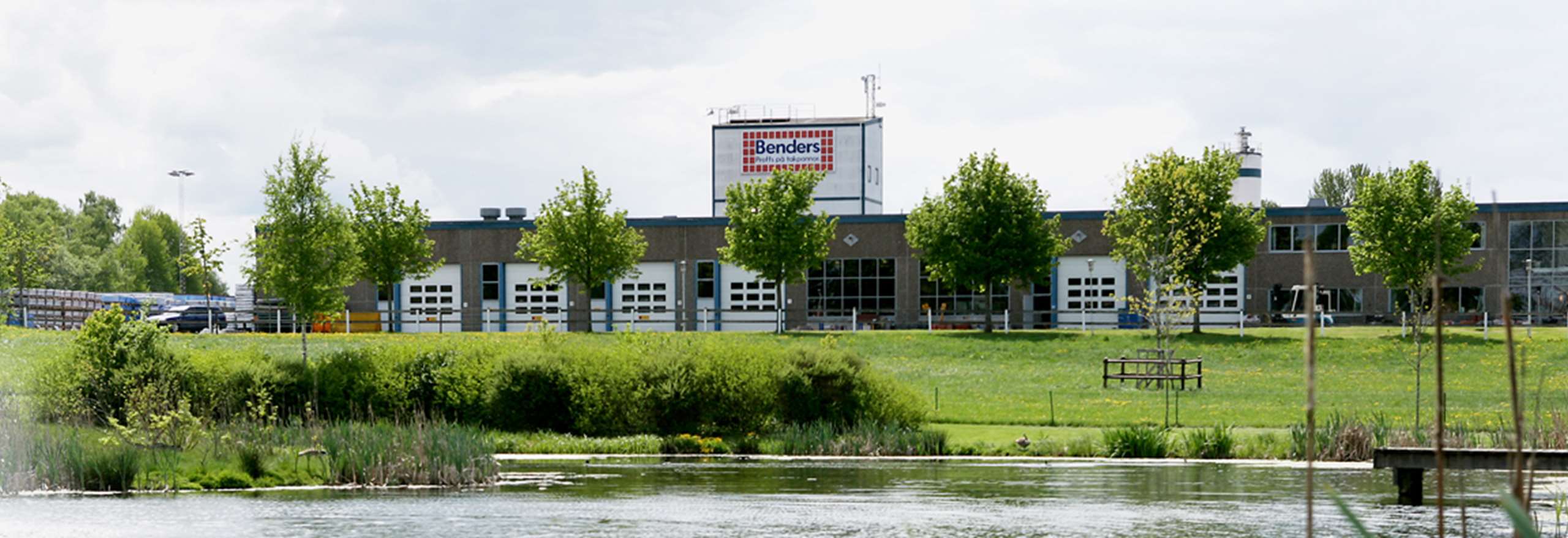 Benders fabrik och huvudkontor i Edsvära. Fabriken ligger bredvid damm och grönområde. 