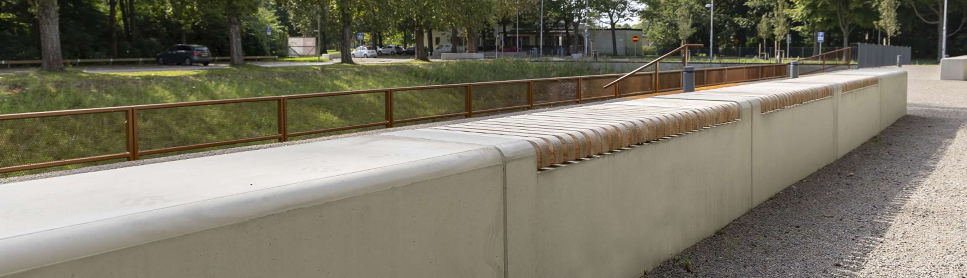 Stilren sittbänk i betong och trä i offentlig miljö.