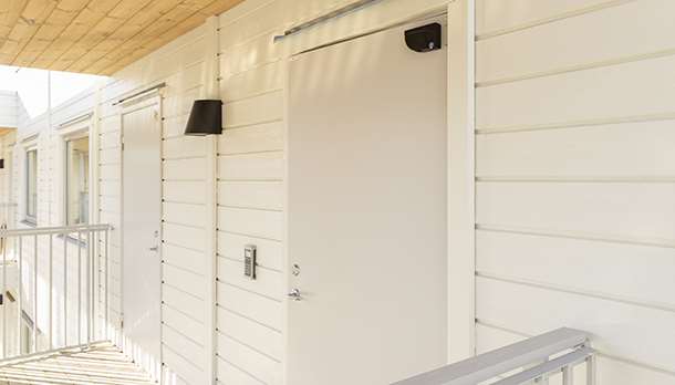 Vita säkerhetsdörrar på ett lägenhetshus.