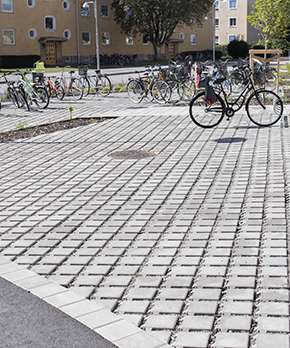 Flera cyklar står parkerade på Benders dränerande marksten Bender Bas Drain fasad.