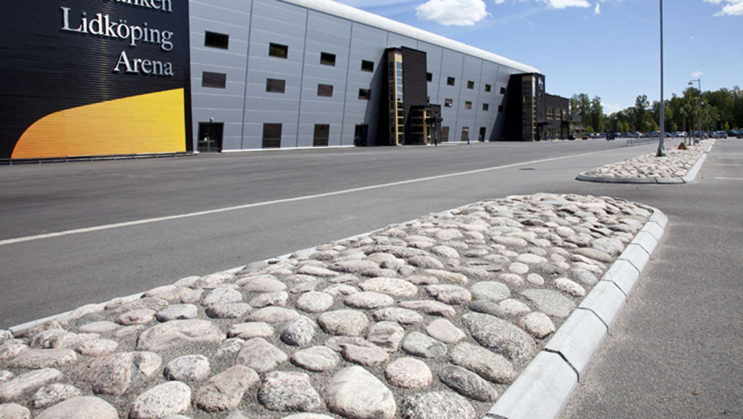 Parkeringsytan utanför Lidköpings arena. Refugen är byggd av Spikma kantsten och kullersten.